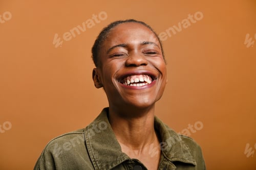 Preview: close up shot of Young black woman laughing with eyes closed in studio