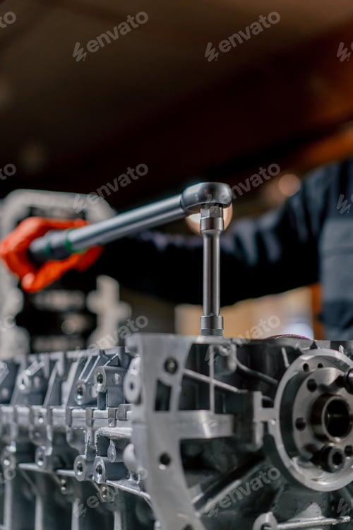 Preview: service station in hands of a master a device for tightening bolts works with bolts on the engine
