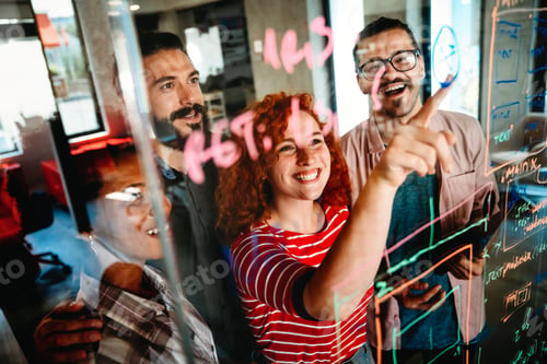 Preview: Diverse group of happy employees analyzing reports with digital device, working together in office
