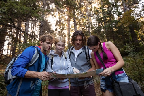 Preview: Group of friends looking at the map while hiking