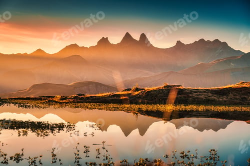 Aperçu: Sunrise shines over Lac Guichard with Arves massif and lake reflection in autumn at Aiguilles dArves