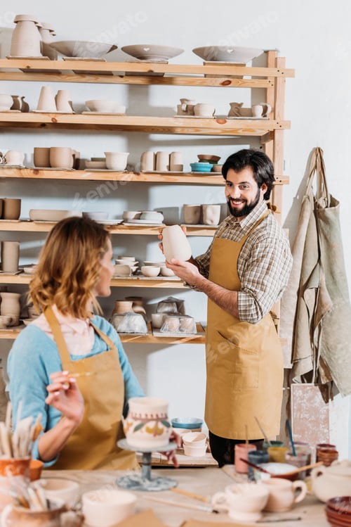 Preview: two potters working with ceramic dishware in workshop