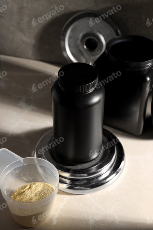 Preview: Black plastic jars, measuring cup and sport equipment on dark gray background