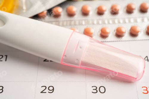 Preview: Pregnancy test and birth control pills on calendar, contraception health and medicine.