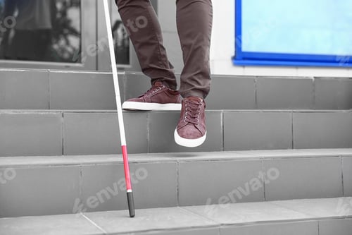 Preview: Blind person with cane going down stairs outdoors, closeup