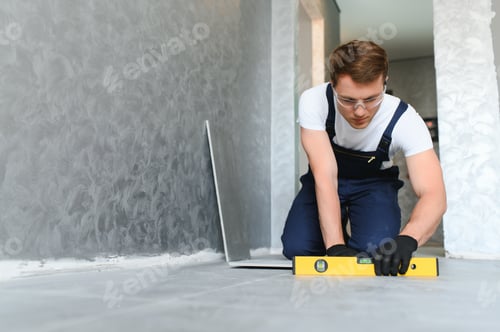 Aperçu: ouvrier industriel, bricoleur installant de grands carreaux de céramique