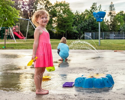 Preview: Little children playing at splash pad in the park. Playground with fountain for kids. Summer fun.