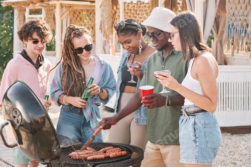 Preview: Man Checking Hot Dogs on Grill