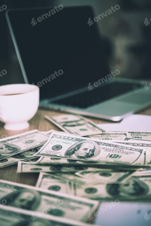 Preview: Working place of trader. The table covered by cash notes, keyboard and financial charts.