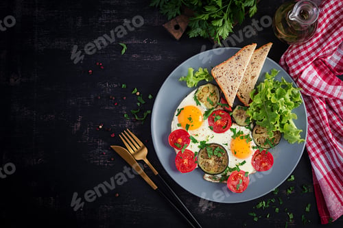 Preview: English breakfast - fried eggs, tomatoes and eggplant. American food. Top view, overhead, copy space