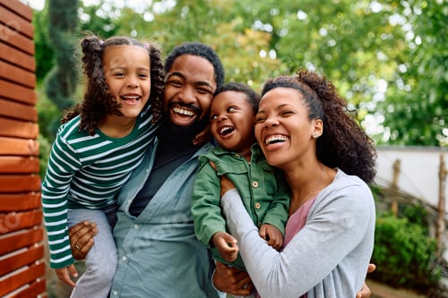 Preview: Happy Family Laughing Together Outdoors in Suburban Setting