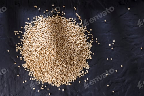 Preview: Quinoa grains with spoon and bowl on black background
