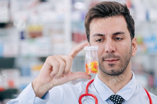 Preview: Doctor Pharmacist man in drug store looking hand holding medicine capsule pills pack
