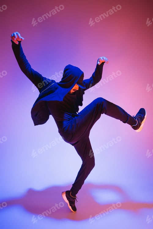 Preview: The silhouette of one hip hop male break dancer dancing on colorful background