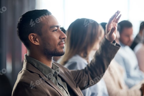 Preview: Shot of a young businessman raising his hand during a conference in a modern office