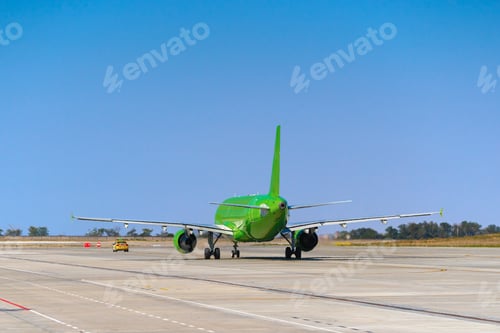 Preview: Green passenger airplane at the airport on sunny day