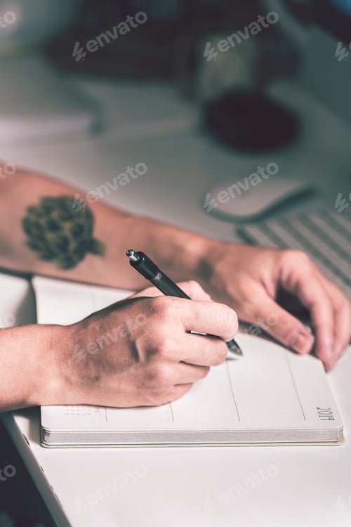 Adult Writing in a 2019 Notebook at Desk
