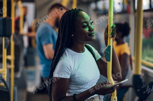 Preview: African american woman using smartphone while riding a bus in the night