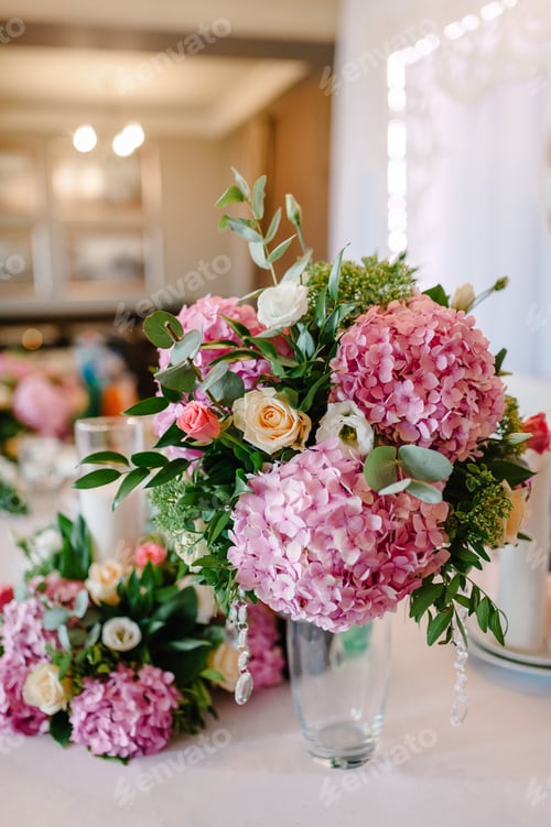 Preview: Wedding decor. Festive table decorated with composition of violet, purple, pink flowers and greenery