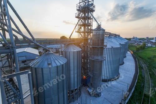Preview: Modern Grain Elevator and Storage Silos at Sunset on Large Agricultural Facility