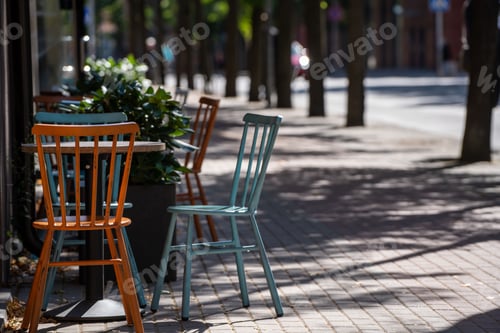 Preview: Table with cute yellow and blue chairs on the corner of the street