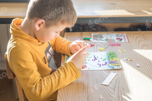 Preview: Little boy being creative making homemade do it yourself dinosaur mosaic. Supporting creativity