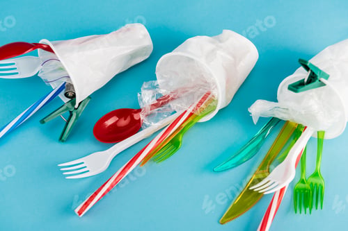 Preview: plastic cups with disposable cutlery on blue background