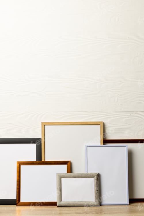 Preview: Vertical of six various empty frames with copy space on table against white wall