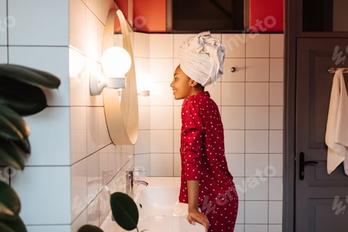 Preview: Portrait of slim girl in pajamas and towel on her head in bathroom