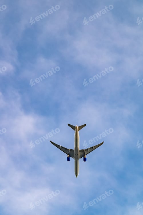 Preview: Commercial airliner flying directly overhead on a sunny blue sky day