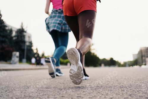 Preview: Two women legs running in the city on the road outdoors. Sports and healthy lifestyle training