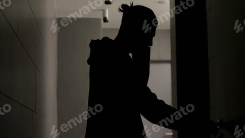 Preview: Talking on the phone. Stock. A handsome man in a black raincoat is talking on the phone with a