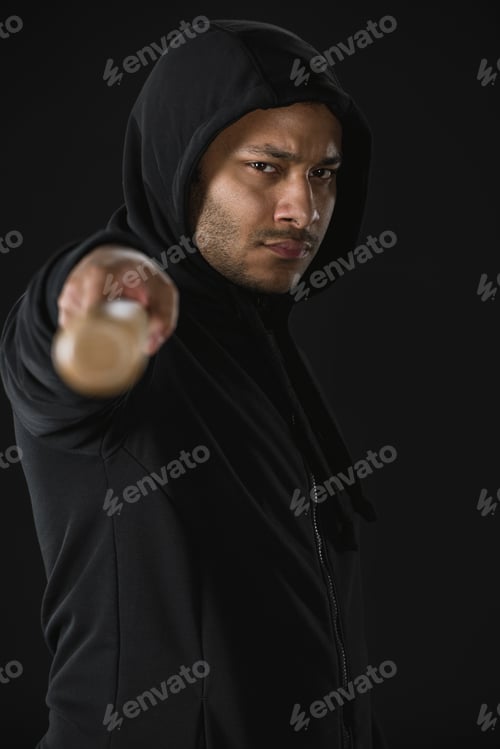 Preview: young african american robber in zoodie with baseball bat isolated on black