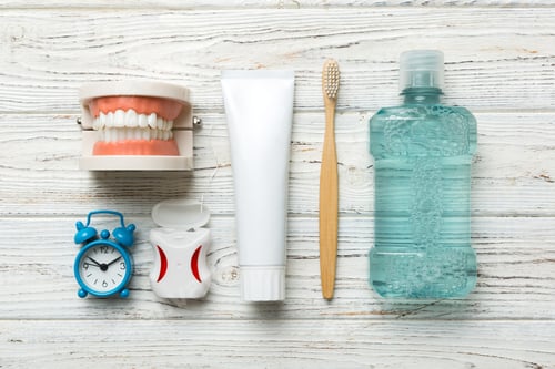 Preview: Mouthwash and other oral hygiene products on colored table top view with copy space. Flat lay.