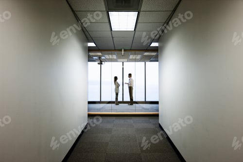 Preview: Business people talkng and standing in front of a window, distant view