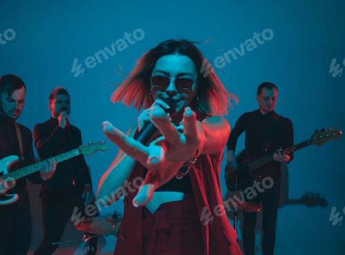 Preview: Young caucasian musicians, band performing in neon light on blue studio background, singer in front