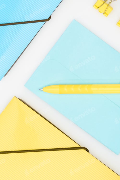 Preview: yellow and blue stationery with folders, pen, envelope and paper clips isolated on white