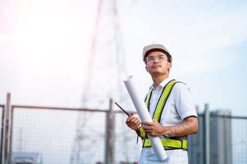 Preview: Electrical engineer using laptop computer standing at power station watching power generation