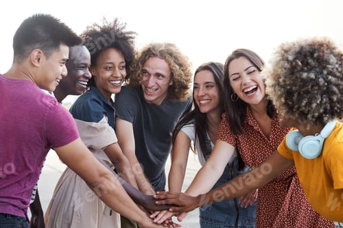 Preview: Friends of different ethnicities stacking hand and looking at each other. Group of people having fun