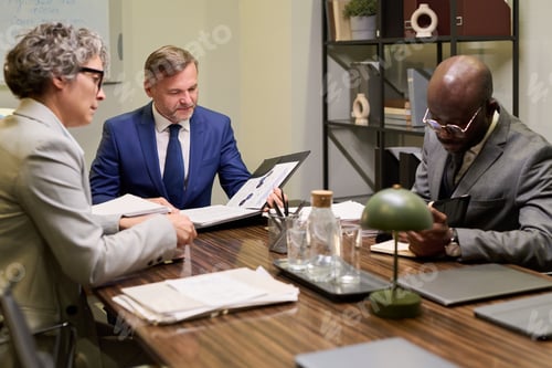Preview: Middle Aged Caucasian Man and Colleagues Analyzing Documents during Meeting