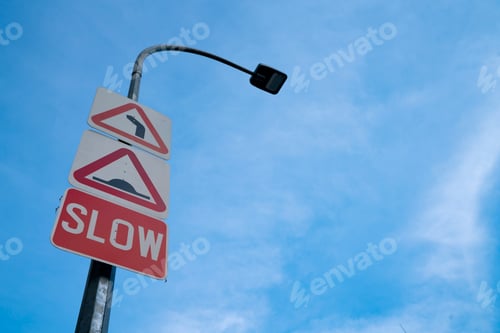 Preview: Slow down road sign on blue sky background with copy space for text or image