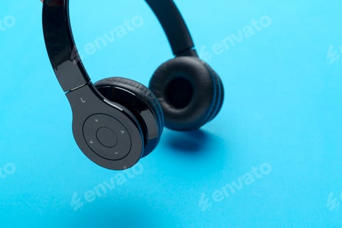 Preview: Headphones on a blue surface with controls for volume and playback features in view