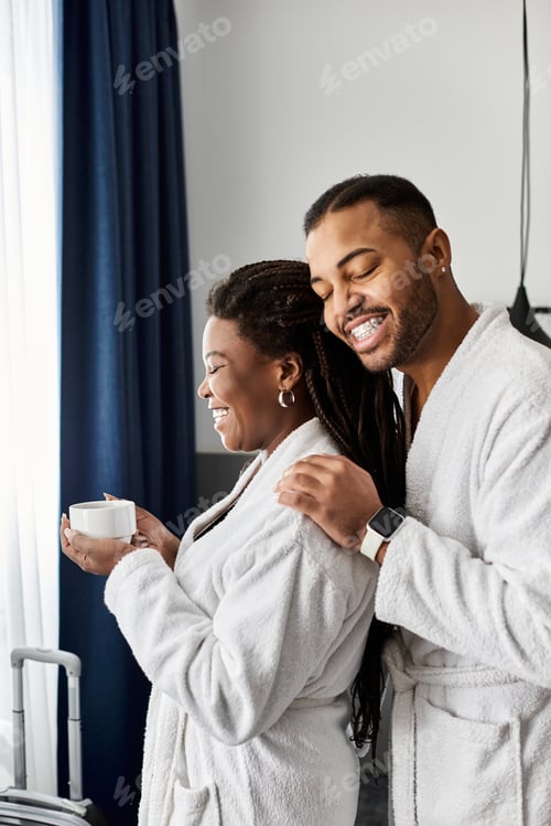 Preview: Young African American couple enjoying a romantic vacation together in a cozy hotel room