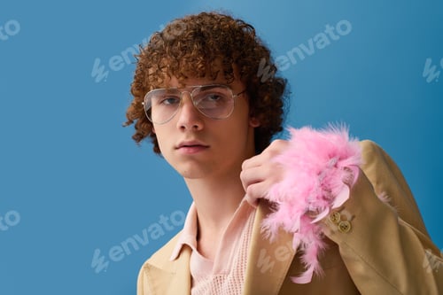 Preview: Teenager exudes confident style in vibrant blue backdrop, showcasing bold fashion choices