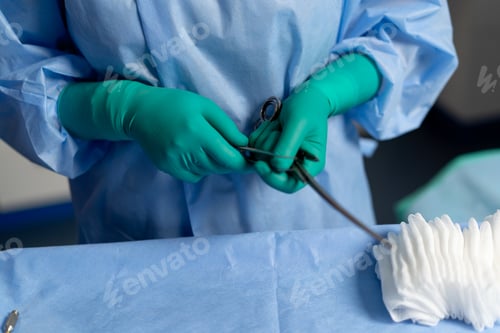 Preview: surgeon in a mask in the operating room stands with a sterilized clamp and shows a super finger