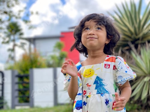 Preview: Kid standing smiling in the garden