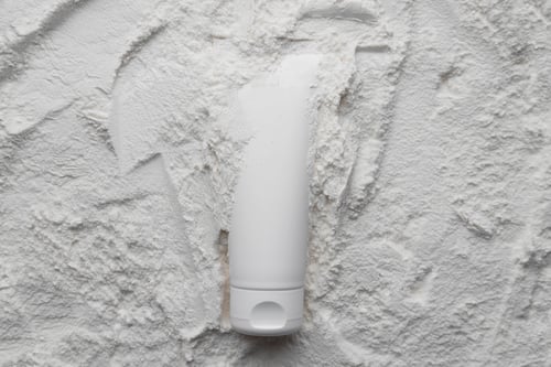 Preview: White cosmetics tube mock up on white powder background. Beauty spa medical skincare