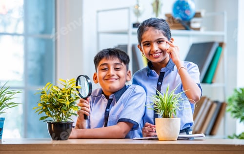 Preview: Indian students in uniform examine plants with magnifying glass during classroom botany lesson