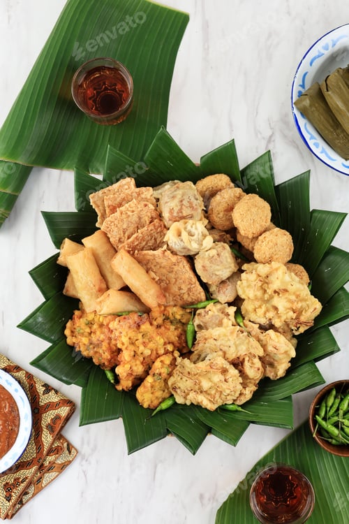 Preview: Top View Aneka Gorengan with Lontong, Green Chilli, and Peanut Sauce.