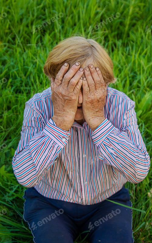 Preview: Old woman feels bad on the street, headache. Selective focus.